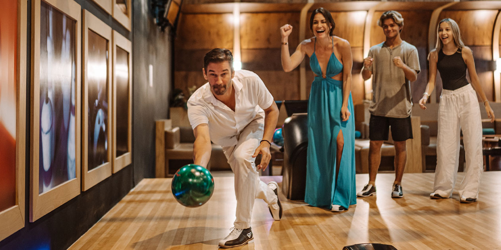 a man throwing a bowling ball in a bowling alley